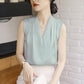 Light blue satin sleeveless blouse with V-neckline and vertical pleats for structure.