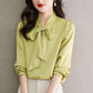 Yellow satin bow-tie neck blouse with long sleeves, button front and gathered cuffs.