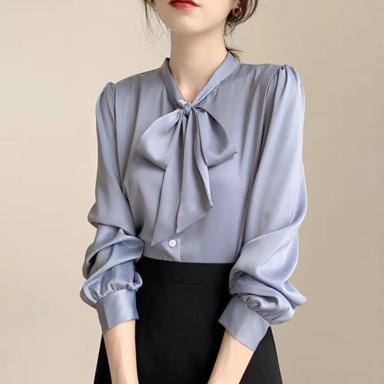 Blue-gray satin bow-tie neck blouse with long sleeves, bow at collar and button front.