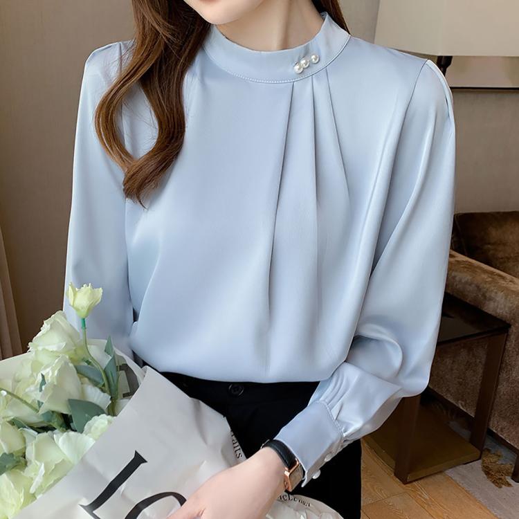 Light blue chiffon mock neck blouse with pearl button detail and long sleeves