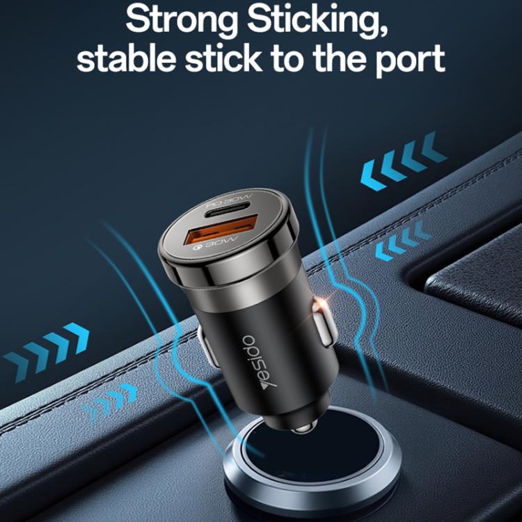 Black car charger plugged into a car outlet, visible USB-A and Type-C ports