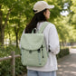 Light green backpack with front flap and drawstring closure