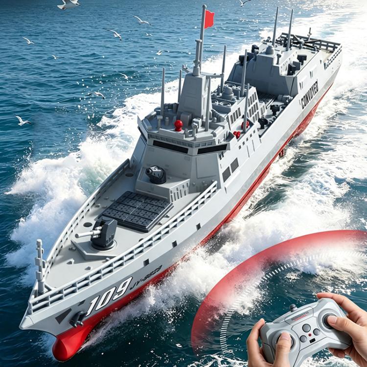 RC destroyer model with red and gray hull, bow forward, remote controller in hands