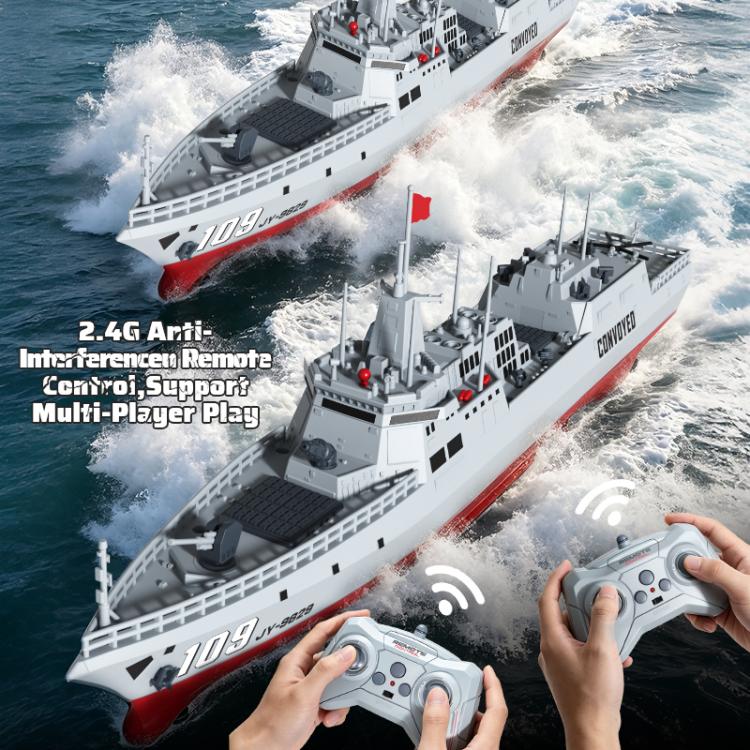 RC destroyer model with two remotes visible, boats on waves and gray superstructure