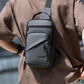 Grey crossbody chest bag worn on chest with adjustable strap and front zipper pocket