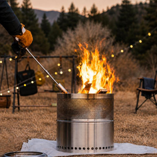 Outdoor camping flame gun with stainless nozzle and wood handle burning over fire pit