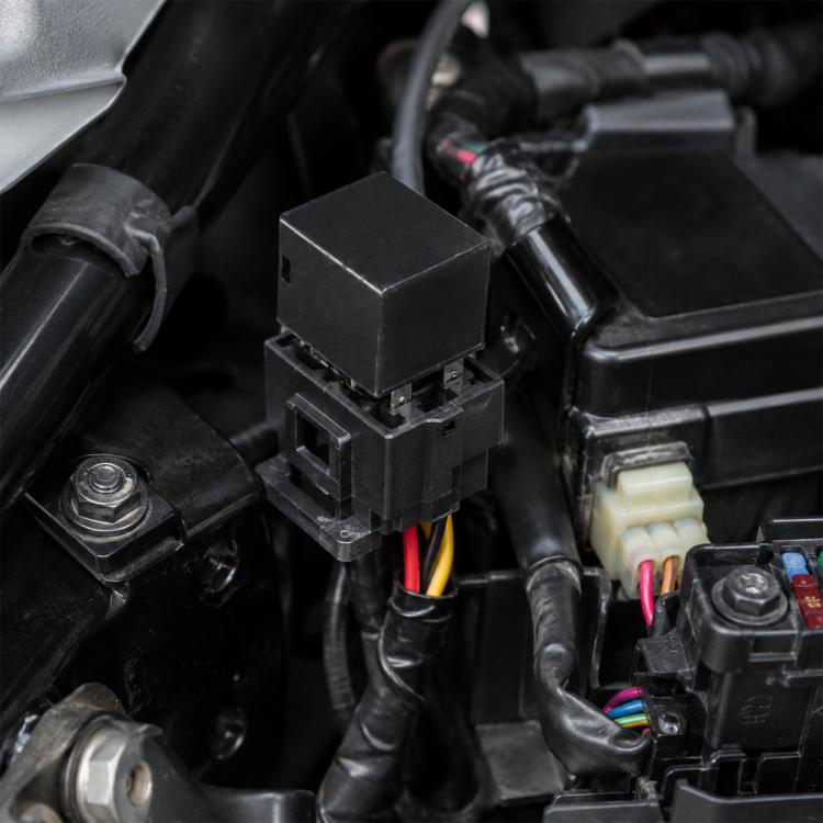 Black 5-pin marine relay with multi-pin housing and wire connectors, shown on vehicle wiring