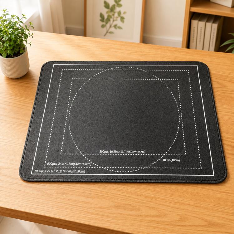 Foldable black puzzle mat with stitched edge, tabletop use view, round puzzle grid design