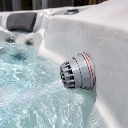 Grey replacement filter cartridge with red sealing ring, attached to a whirlpool wall