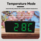 LED digital clock in temperature mode with green digits, black housing