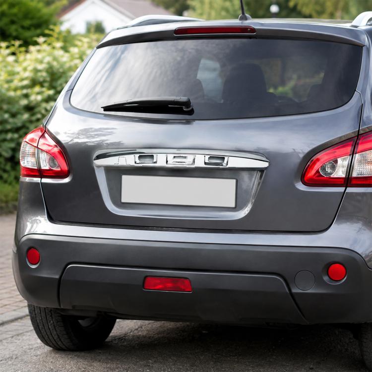 Chrome rear tailgate handle cover on a dark car, centered on the trunk panel.
