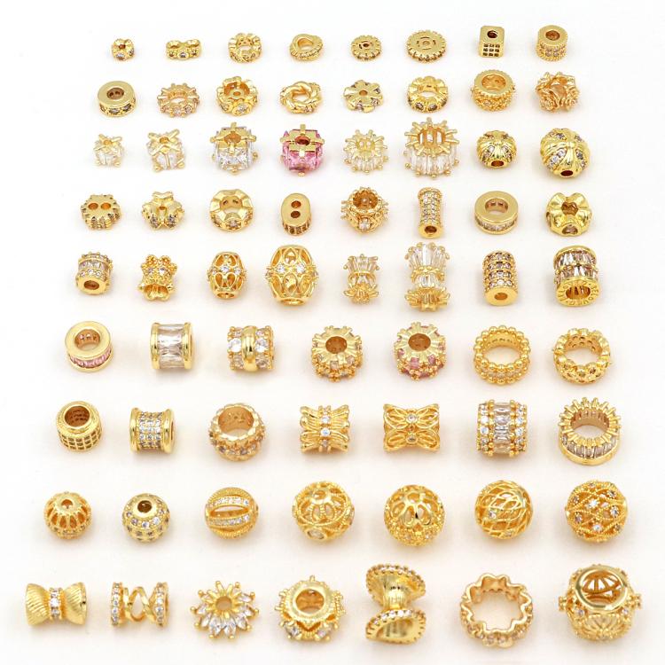 Gold zircon spacer beads, assorted small shapes shown in a tray for DIY jewelry