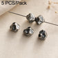Four small dark silver cube-like bead spacers with holes on a pin, textured finish