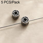 Two round dark silver beads with star-like carved patterns and central holes