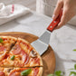 Stainless steel pizza spatula with wooden handle, lifting a slice from a wooden board