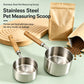Stainless steel pet measuring scoops with wooden handles on a wooden board and tray