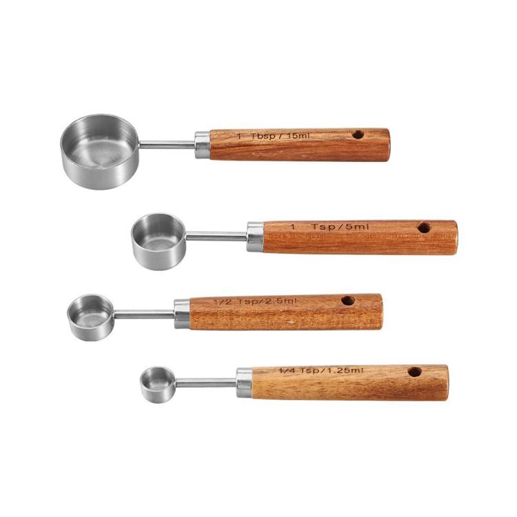 Stainless steel measuring cup spoon set with wooden handles, four nested sizes on white