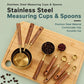 Stainless steel measuring cup and spoon set with wooden handles and gold bowls