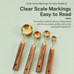 Stainless steel measuring spoons with engraved measurement markings and wooden handles