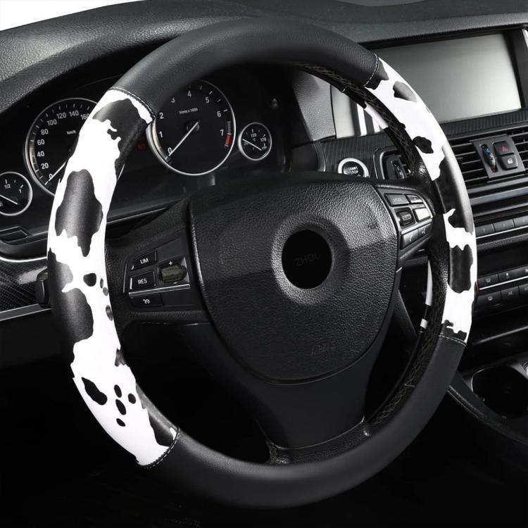Cow print steering wheel cover in black and white, wrapping wheel grips and spokes