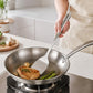 Stainless steel slotted cooking spatula with perforated head for turning food in a pan
