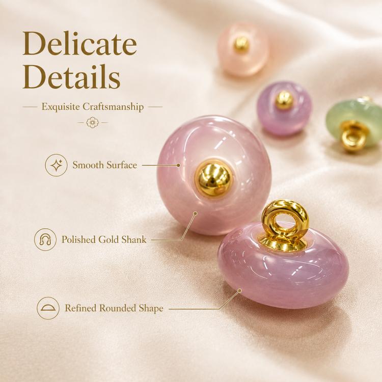 Close-up of pink resin disc buttons with gold shanks and loops, glossy finish