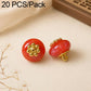 Red resin flat flower-shank buttons with gold decorative flower tops, 2 shown