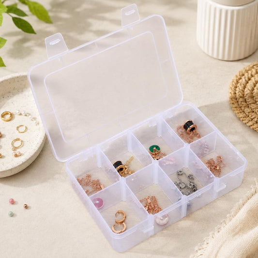 Clear plastic organizer box with 8 compartments, open lid showing assorted small jewelry.