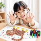 Child at table with carrot crayon drawing and small tray of colorful crayons