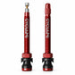Pair of red Presta tubeless valve extenders with long aluminum stems and rubber bases