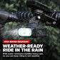 Weather-resistant bike front headlight with beam on rainy road in spray