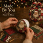 Hands assembling a Santa patchwork ornament on a foam base with pins and beads