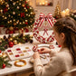 Child hands assembling a red and white pearl Christmas wreath with satin bow centerpiece