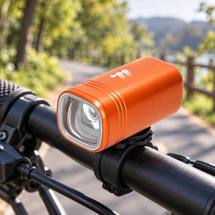 Orange bike headlight cylinder with clear front LED lens on handlebar mount