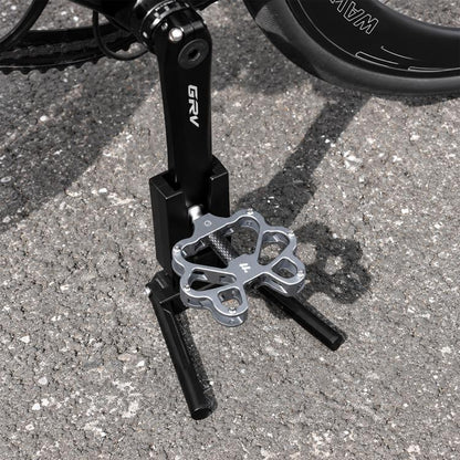 Black bike crank kickstand with folding kick feet and metal mounting bracket