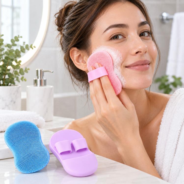 Pink silicone finger face cleansing brush held against cheek for gentle scrubbing