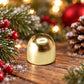 Gold-tone metal wind chime bell ornament standing with a top hanging hole.