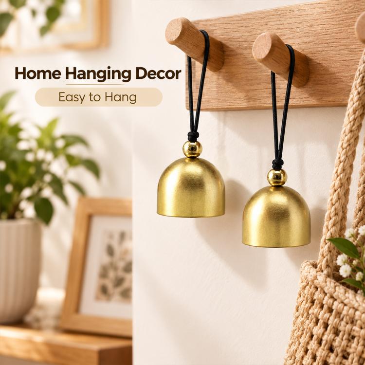 Two gold metal hanging bell ornaments on wooden hooks with black cords