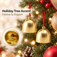 Gold metal bell ornaments hanging on a Christmas tree with red cords