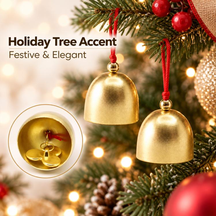 Gold metal bell ornaments hanging on a Christmas tree with red cords