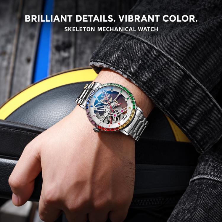 Men's automatic skeleton watch on wrist, silver steel bracelet, multicolor gem bezel