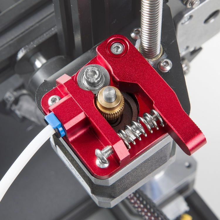 Close-up of red metal Bowden extruder drive with gear and mounting base