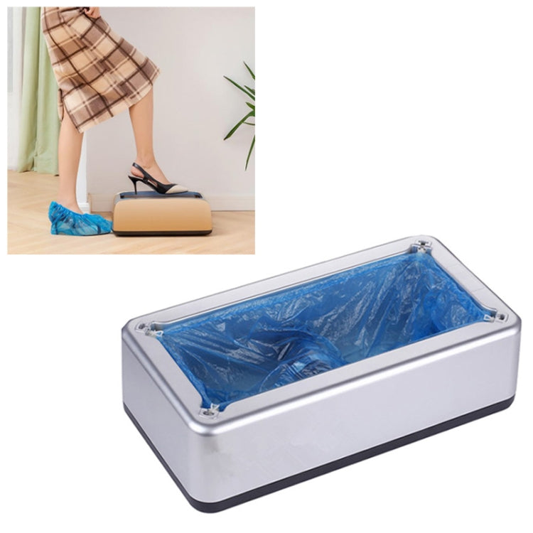 Silver shoe cover machine with clear tray holding blue disposable shoe covers