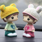 Resin cartoon couple ornament, side view: yellow and white bear-hat boy and girl on base