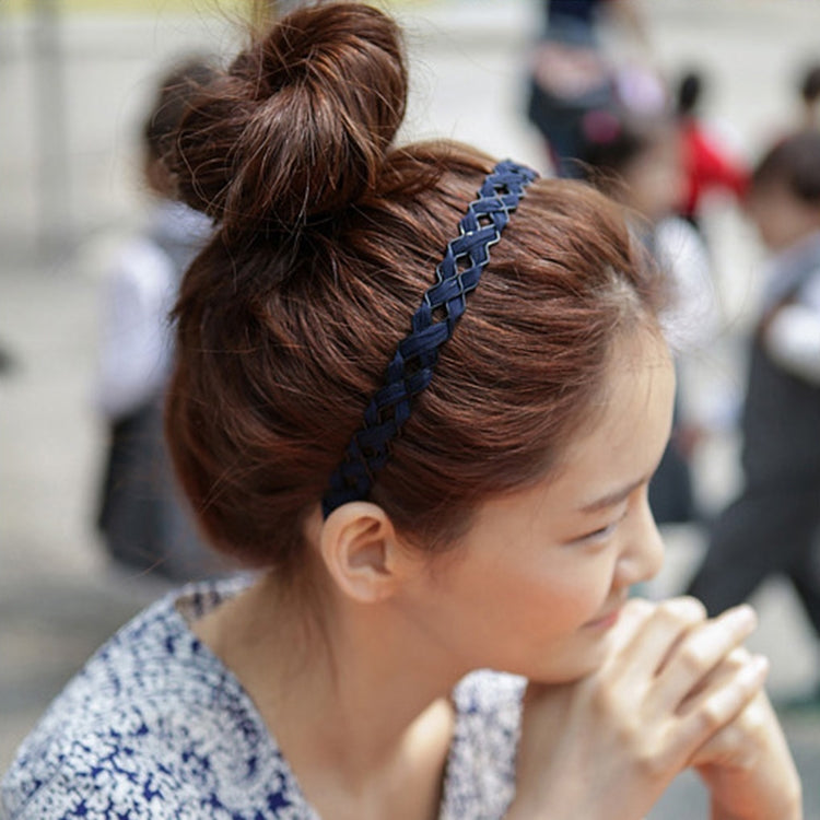 Dark blue braided hair hoop headband on a bun hairstyle, side view on a woman.