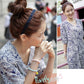 Dark blue braided hair hoop headband on bun hairstyle, woman smiling outdoors.