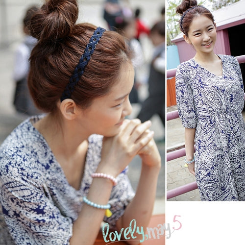 Dark blue braided hair hoop headband on bun hairstyle, woman smiling outdoors.