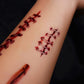 Close-up of temporary tattoo stickers showing stitched scar and red cut marks on arm