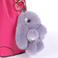 Lavender rex rabbit plush keychain pendant attached to a pink bag loop