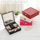 Stacked red and pink wooden jewelry organizer boxes with quilted lids and locks